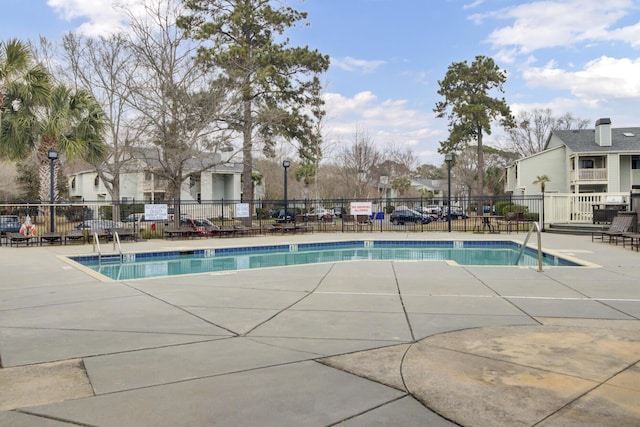 community pool featuring a patio and fence