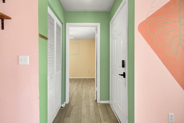 hallway with wood finished floors and baseboards