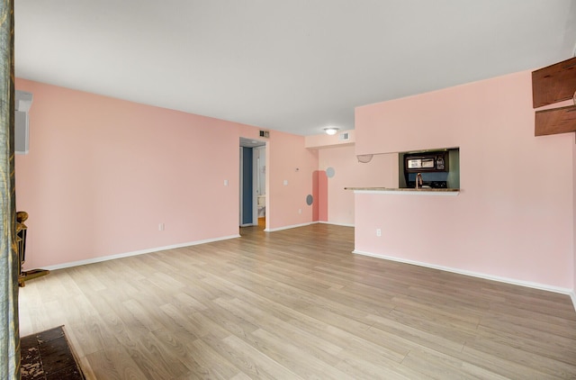 unfurnished living room with visible vents, baseboards, and light wood-style floors