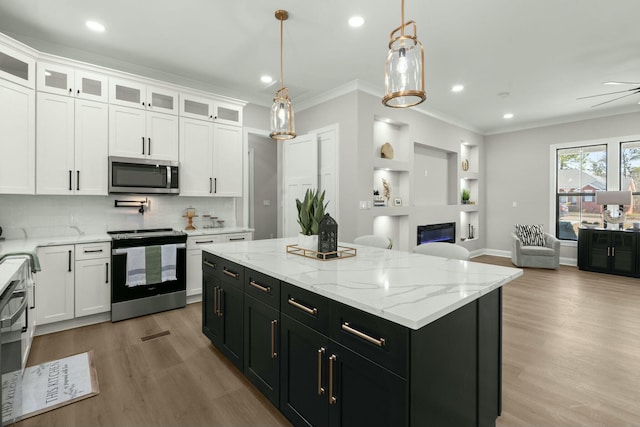 kitchen with range with electric cooktop, a kitchen island, stainless steel microwave, open floor plan, and dark cabinetry