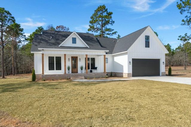 modern farmhouse featuring driveway, an attached garage, a front lawn, and a porch