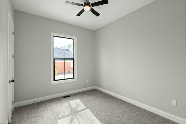 empty room featuring baseboards, visible vents, ceiling fan, and light colored carpet