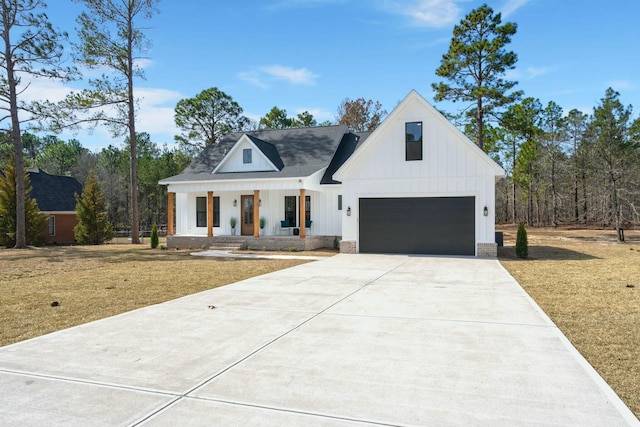 modern inspired farmhouse featuring a garage, covered porch, board and batten siding, and concrete driveway