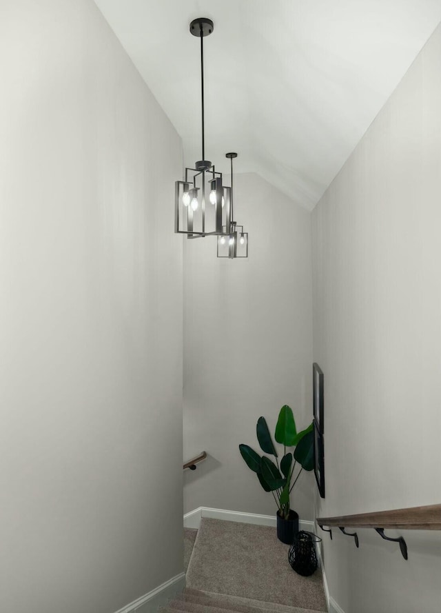 staircase featuring lofted ceiling, carpet flooring, and baseboards