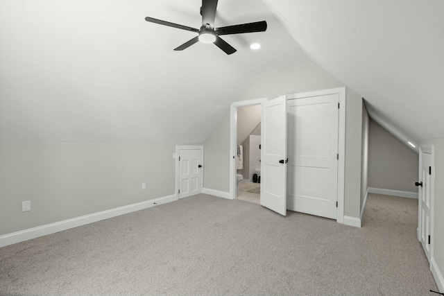 additional living space with light carpet, baseboards, and lofted ceiling