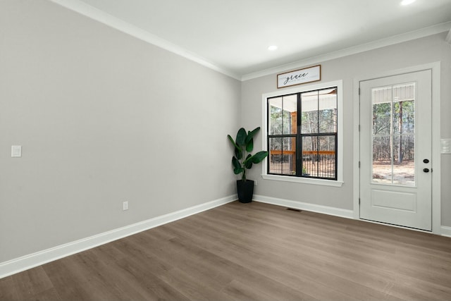 spare room with crown molding, recessed lighting, visible vents, wood finished floors, and baseboards