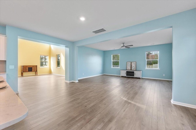 unfurnished living room with ceiling fan and light hardwood / wood-style floors