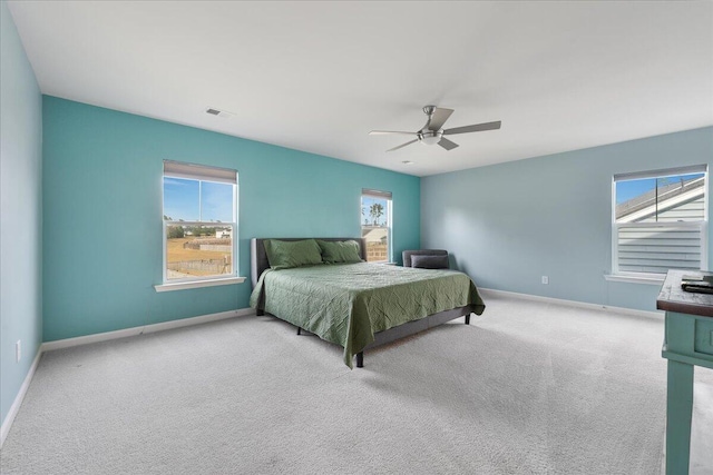 carpeted bedroom featuring multiple windows and ceiling fan