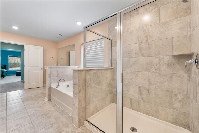 bathroom with tile patterned floors and shower with separate bathtub