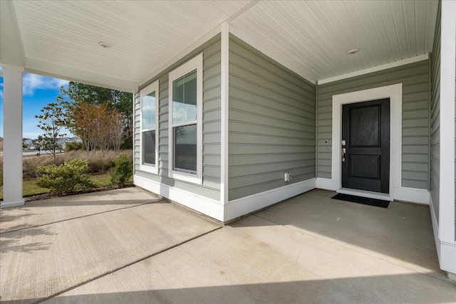 view of exterior entry featuring covered porch