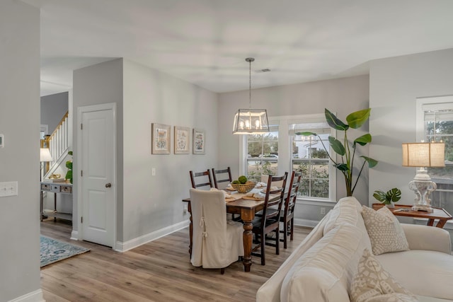 dining room with wood-type flooring and a chandelier