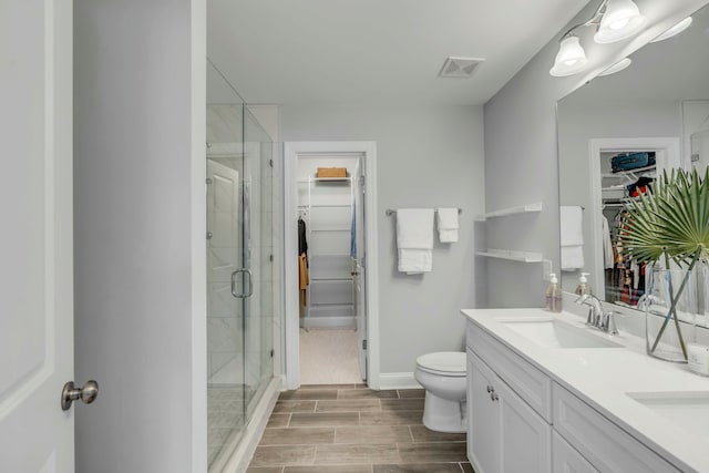 bathroom with a shower with door, toilet, and vanity