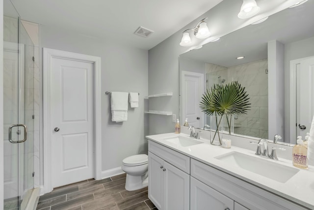 bathroom with toilet, walk in shower, and vanity