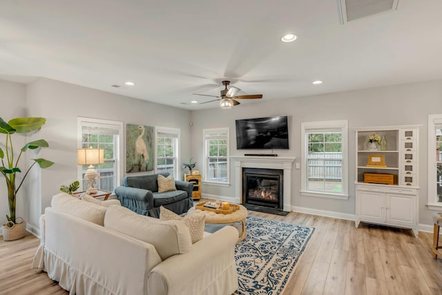 living room with ceiling fan, light hardwood / wood-style floors, and plenty of natural light