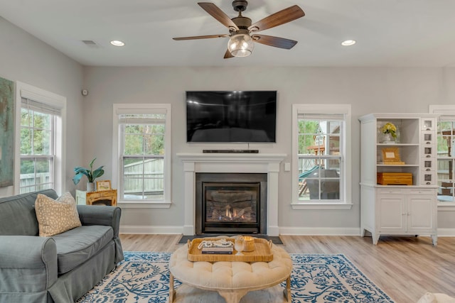 living room with ceiling fan and light hardwood / wood-style flooring