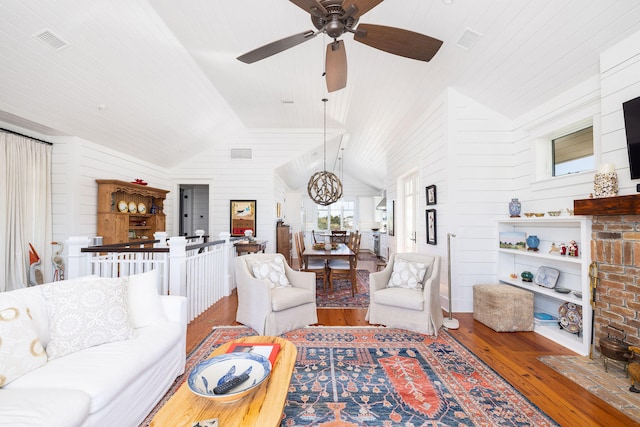 living room featuring hardwood / wood-style flooring, lofted ceiling, and ceiling fan with notable chandelier