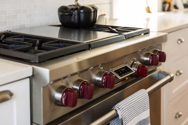 room details featuring decorative backsplash and high end stainless steel range