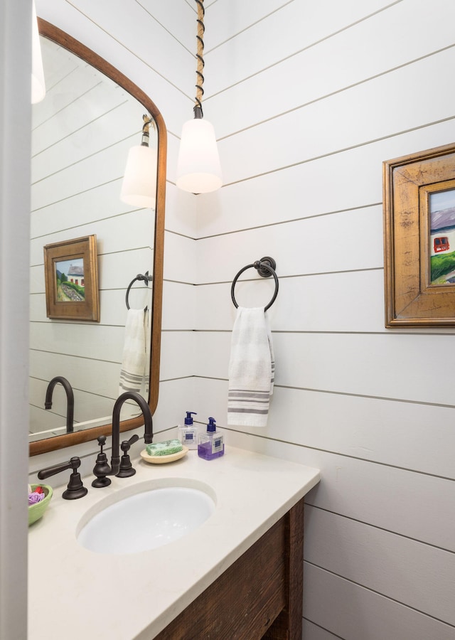 bathroom with vanity and wooden walls