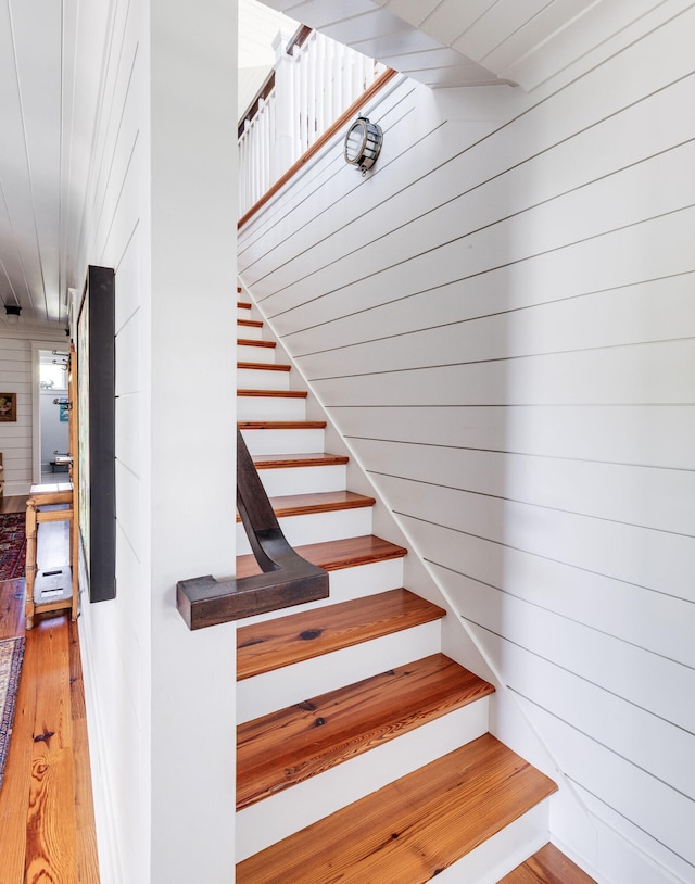 stairs with wooden walls and wood-type flooring