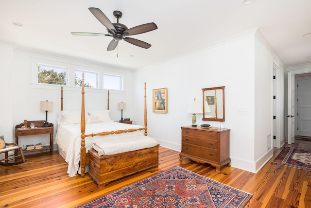 bedroom with crown molding, wood-type flooring, and ceiling fan