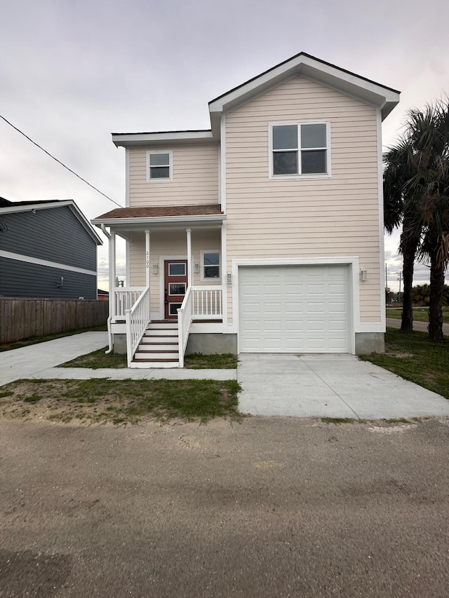 view of front of house featuring driveway, an attached garage, and a porch