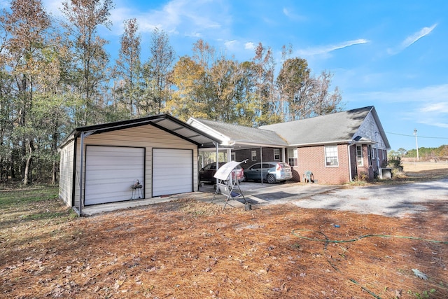 view of front of property featuring an outbuilding, brick siding, and an attached garage