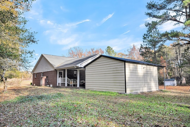 back of house featuring a yard and brick siding