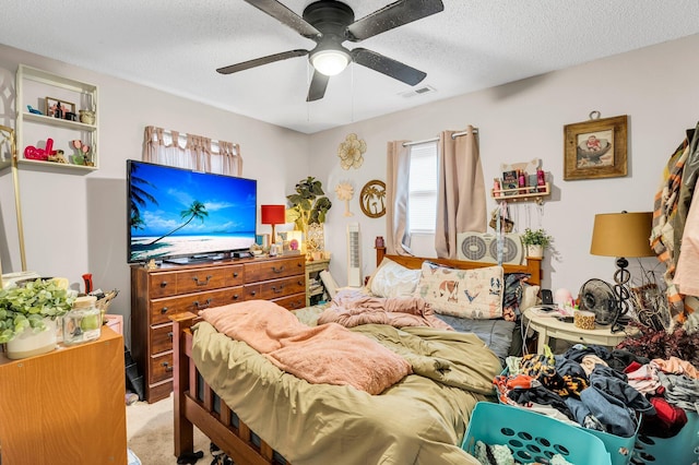 bedroom with a textured ceiling, a ceiling fan, visible vents, and light colored carpet