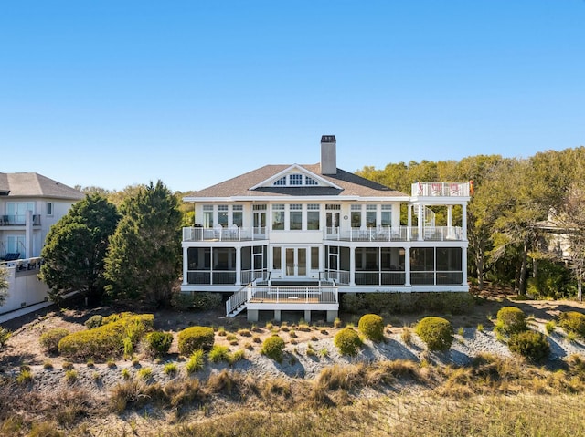 back of property with a balcony and a chimney