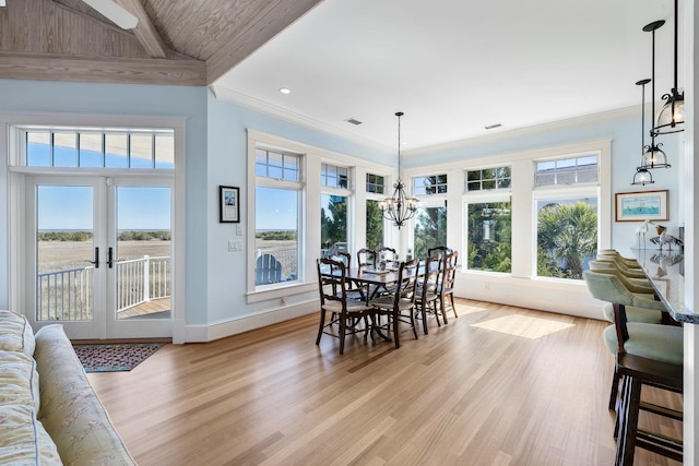 dining area featuring baseboards, ornamental molding, french doors, an inviting chandelier, and light wood-style floors