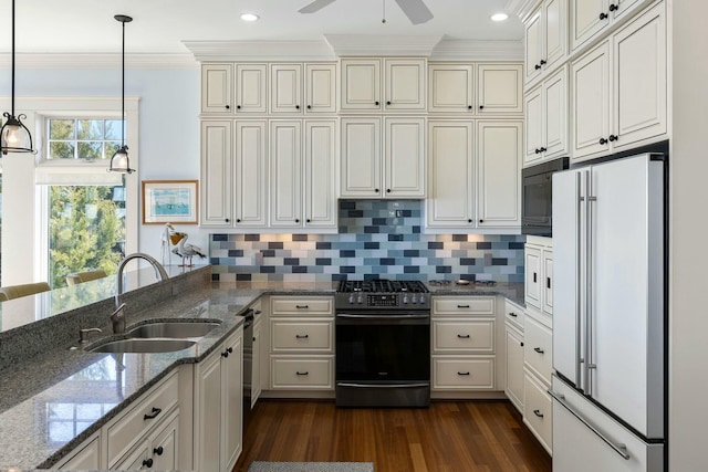 kitchen with stainless steel range with gas stovetop, freestanding refrigerator, a sink, decorative backsplash, and black microwave