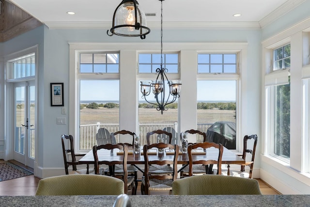 dining area featuring a notable chandelier, plenty of natural light, visible vents, and ornamental molding