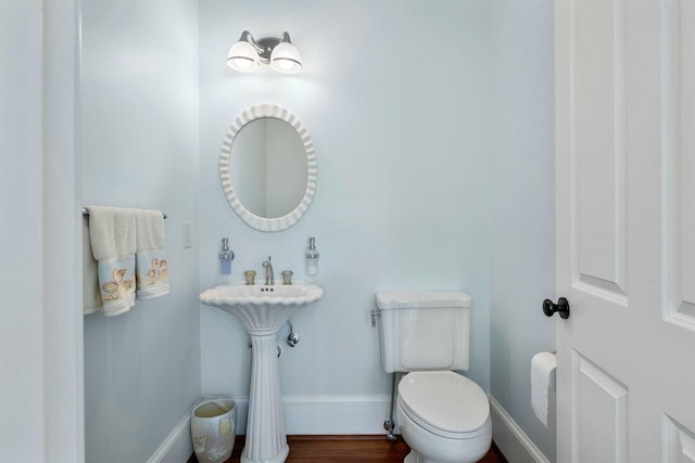 bathroom featuring toilet, wood finished floors, and baseboards