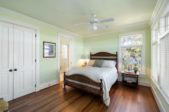 bedroom featuring a closet, baseboards, dark wood finished floors, and crown molding