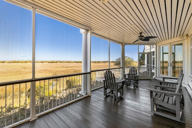 unfurnished sunroom with ceiling fan