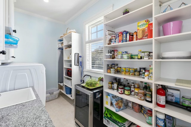 storage area with washer / dryer, wine cooler, and a sink