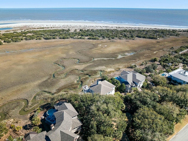 birds eye view of property with a water view and a beach view