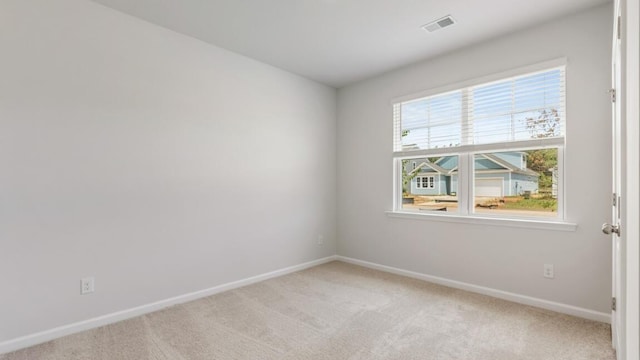 unfurnished room featuring a wealth of natural light and light carpet