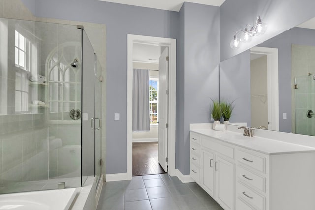 bathroom with tile patterned flooring, vanity, and walk in shower