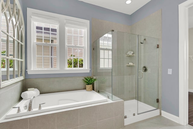 bathroom with tile patterned flooring and shower with separate bathtub