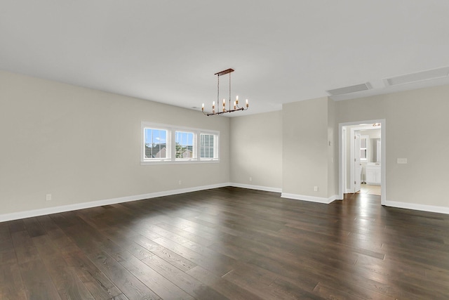 empty room featuring dark hardwood / wood-style floors and a notable chandelier