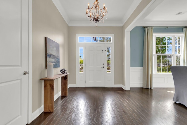 foyer entrance featuring an inviting chandelier, dark hardwood / wood-style floors, and ornamental molding