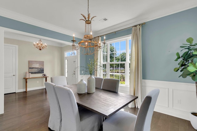 dining room featuring dark hardwood / wood-style floors, crown molding, and a chandelier