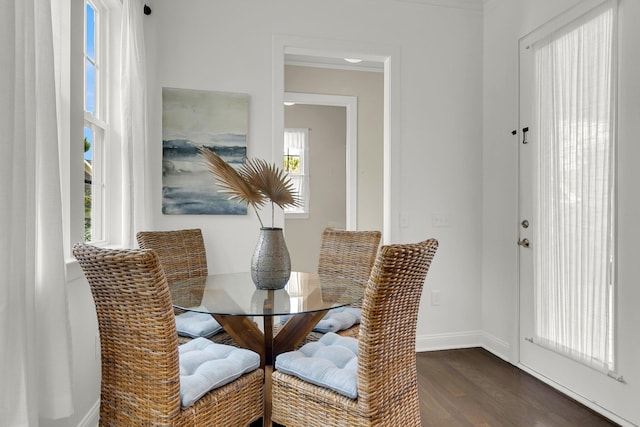 dining area with dark wood-type flooring and ornamental molding