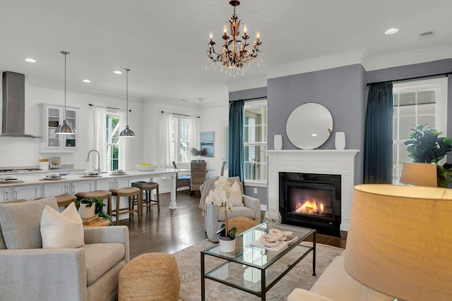 living room featuring crown molding, light hardwood / wood-style flooring, and a notable chandelier