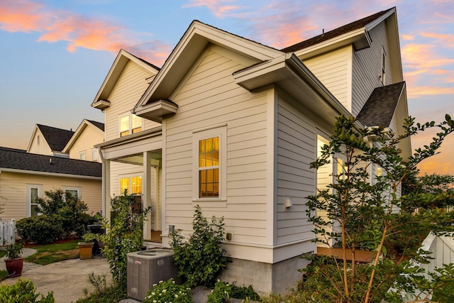 property exterior at dusk featuring central AC and a patio