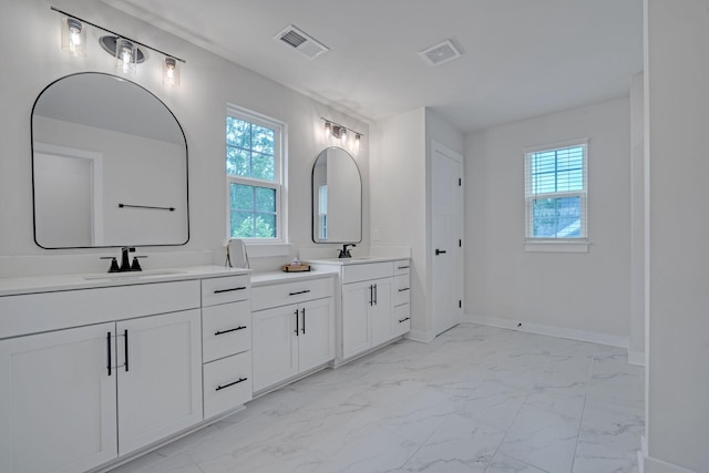 445 Oswego Ct, Greenville, SC 29607 - bathroom with marble look tiles, plenty of natural light, two vanities, and baseboards