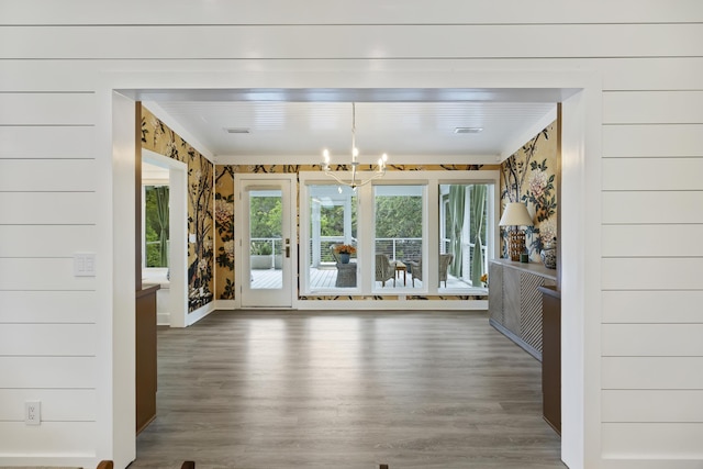 1075 Wayfarer Ln, Charleston, SC 29412 - unfurnished dining area with wallpapered walls, wood finished floors, a chandelier, and crown molding