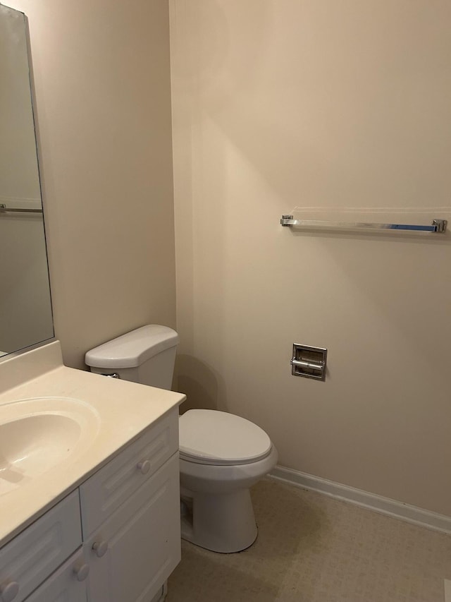 bathroom with toilet, baseboards, and vanity