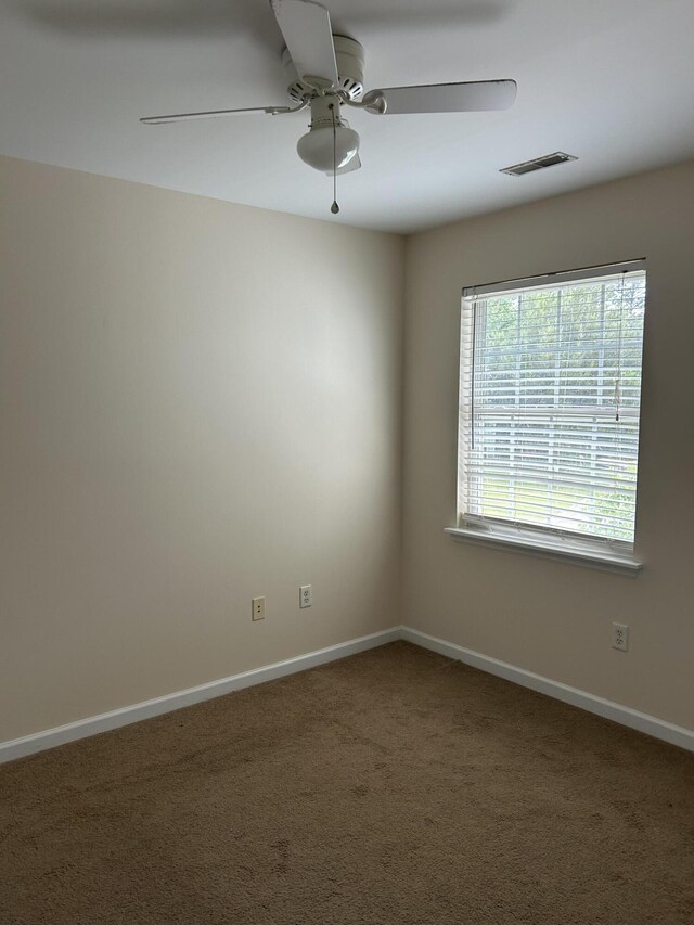 spare room with visible vents, a ceiling fan, carpet, and baseboards